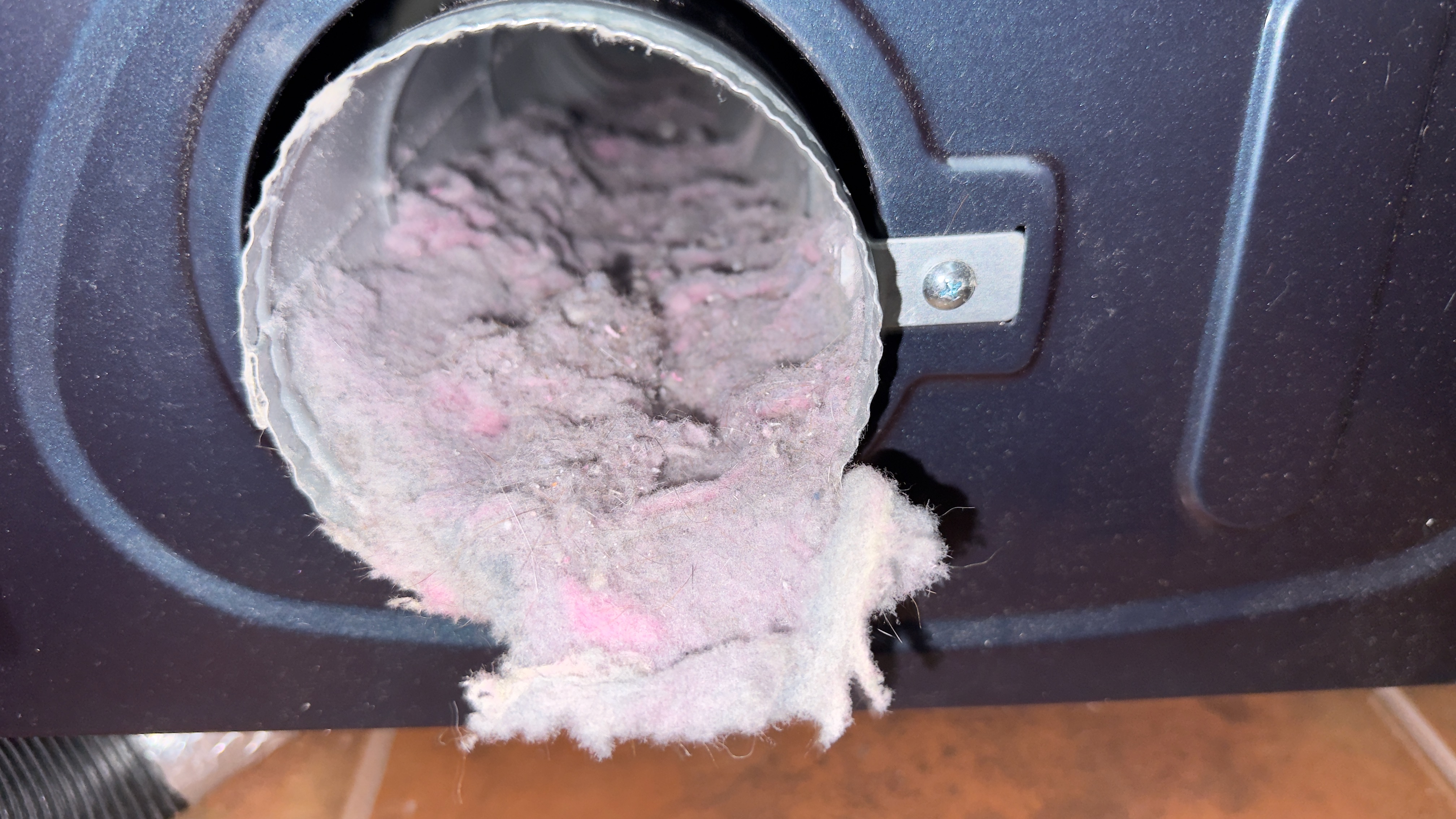 Dryer vent outlet packed with lint before cleaning